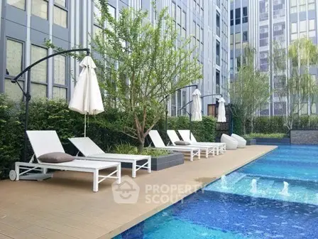 Luxurious apartment complex with modern poolside and sun loungers.