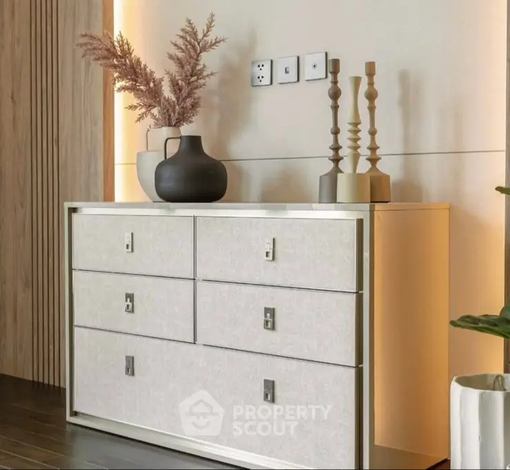 Elegant modern dresser with decorative vases and candlesticks in stylish interior setting.