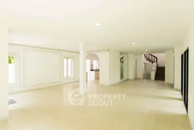 Spacious open-plan living area with modern staircase and natural light