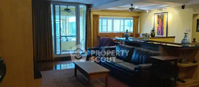 Spacious living room with leather sofa and balcony access in modern apartment