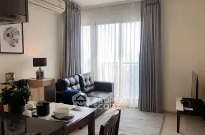 Modern living room with sleek furniture and large windows offering natural light.