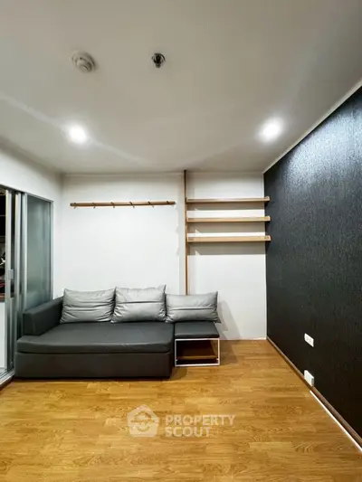 Modern living room with sleek gray sofa and wooden flooring