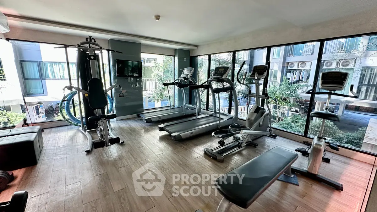 Modern gym with state-of-the-art equipment and large windows offering a scenic view.