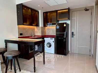 Modern kitchen with sleek black appliances and integrated washing machine in stylish apartment.