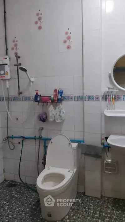 Cozy bathroom with essential amenities and floral tile accents