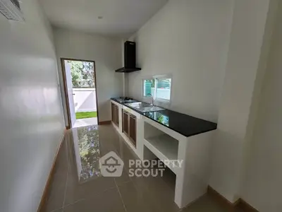 Sleek modern kitchen with open layout and glossy tile flooring