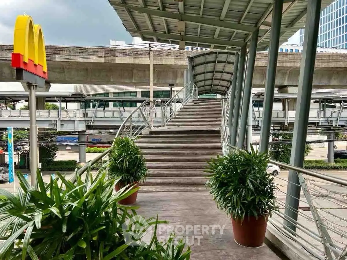 Modern urban walkway with covered stairs and lush potted plants