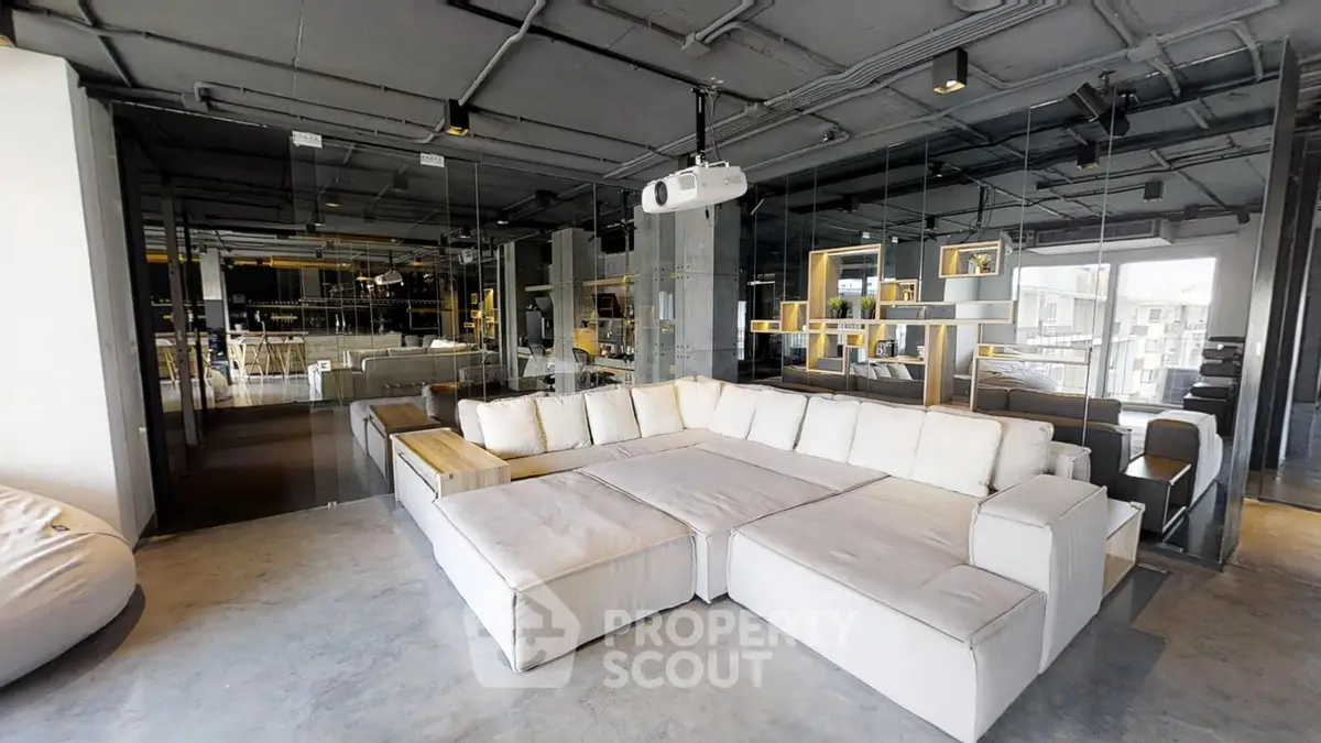 Spacious modern living room with large sectional sofa and mirrored walls