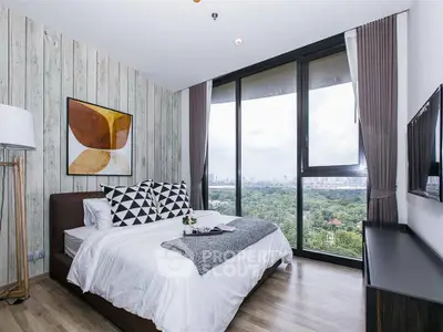 Modern bedroom with large windows offering stunning cityscape views.