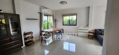 Spacious living room with modern furniture and large windows offering natural light and garden view.
