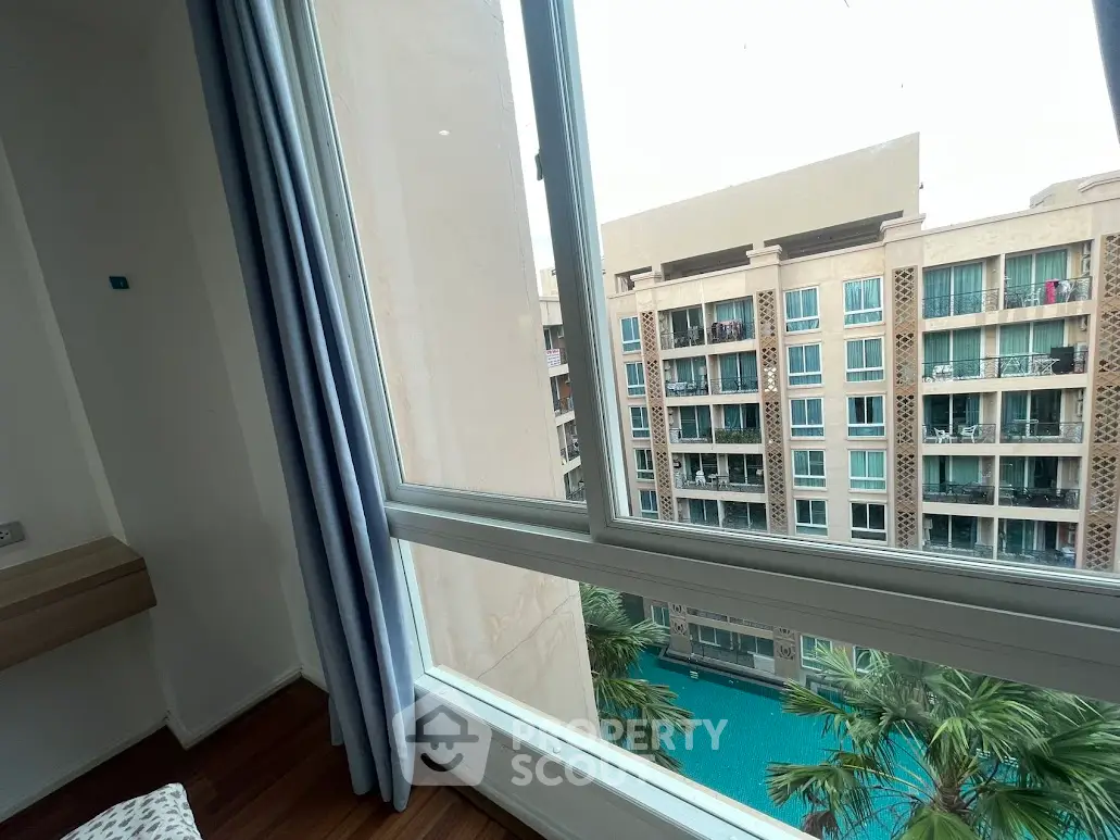 Spacious apartment with pool view and large windows for natural light.