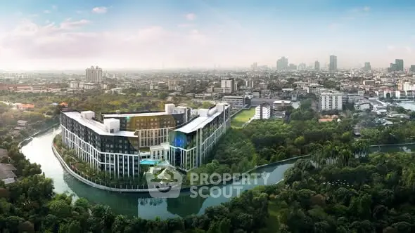 Stunning aerial view of modern riverside residential complex in lush green surroundings.