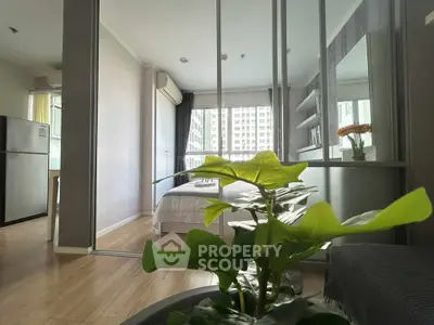 Modern bedroom with large window and plant, featuring sleek design and natural light.
