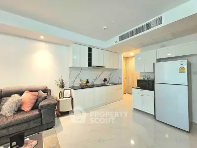 Modern open-layout living room with sleek kitchen and cozy sofa, perfect for urban living.