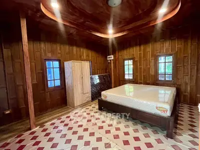 Spacious wooden bedroom with unique ceiling design and large windows