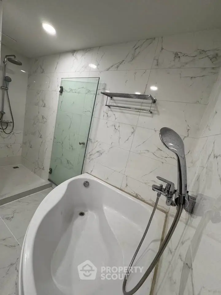 Luxurious bathroom with marble tiles and modern bathtub, perfect for relaxation.