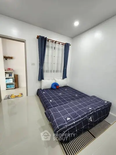 Cozy bedroom with modern decor and natural light, perfect for relaxation and comfort.