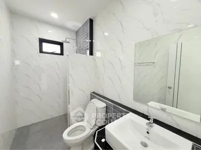 Modern bathroom with sleek white marble tiles and contemporary fixtures
