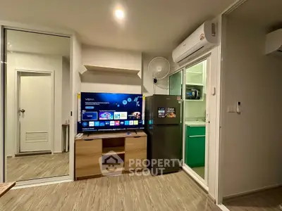 Modern living room with smart TV, air conditioning, and sleek kitchen access.