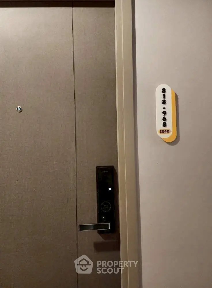 Modern apartment entrance with sleek door and electronic lock