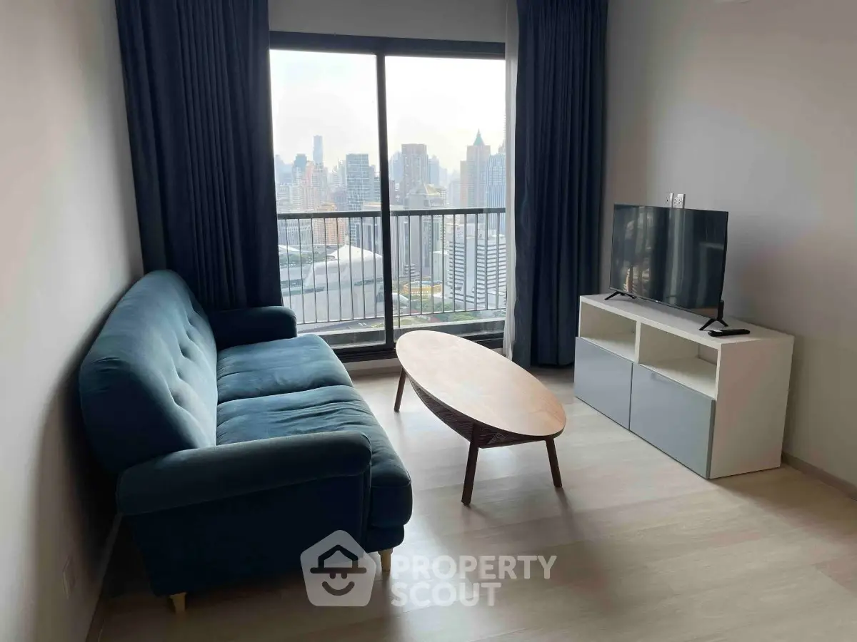 Modern living room with city view, featuring a stylish sofa and TV setup.