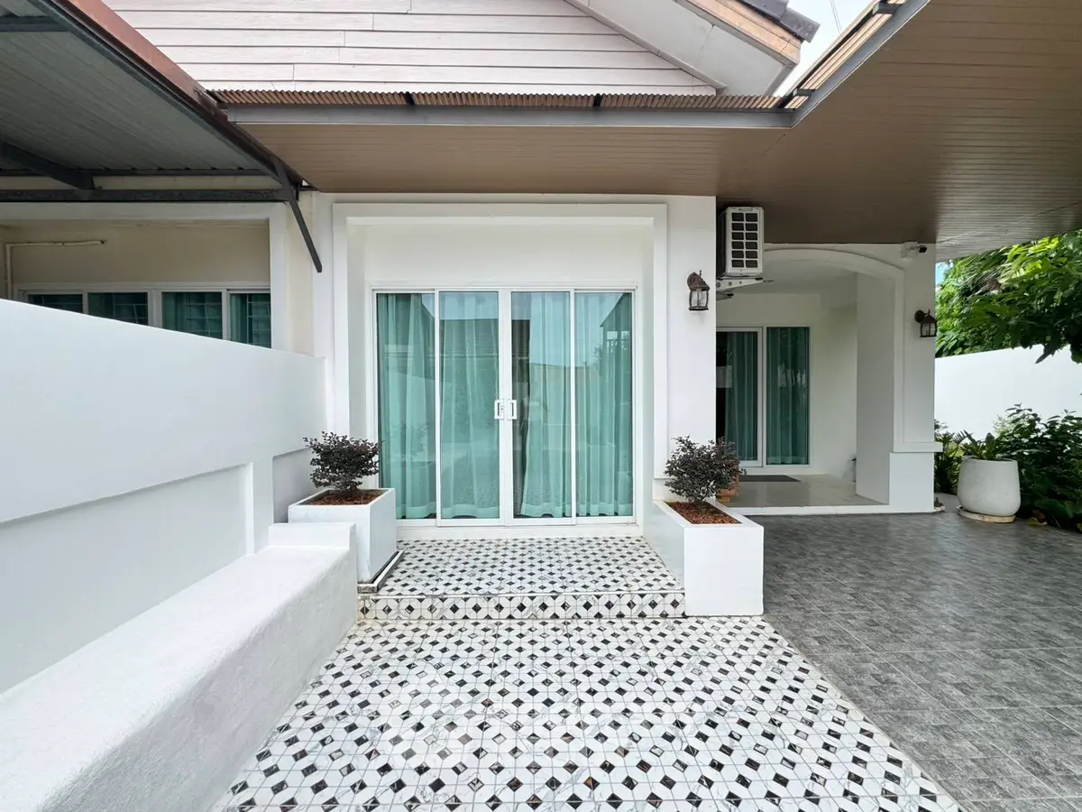Charming modern home exterior with stylish patio and elegant sliding glass doors.