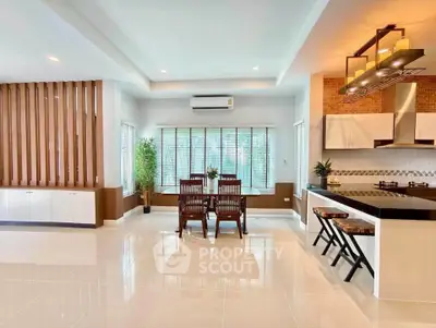 Spacious modern living room with open kitchen and elegant dining area, featuring sleek design and natural light.