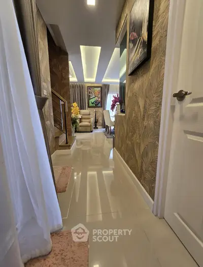 Luxurious hallway leading to a stylish living room with elegant decor and modern lighting.