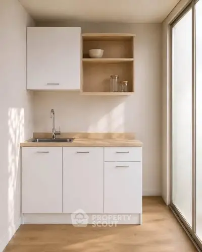 Modern minimalist kitchen with sleek white cabinets and natural light
