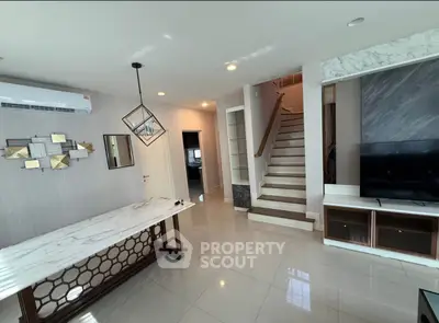 Modern living room with stylish decor and staircase in a contemporary home.