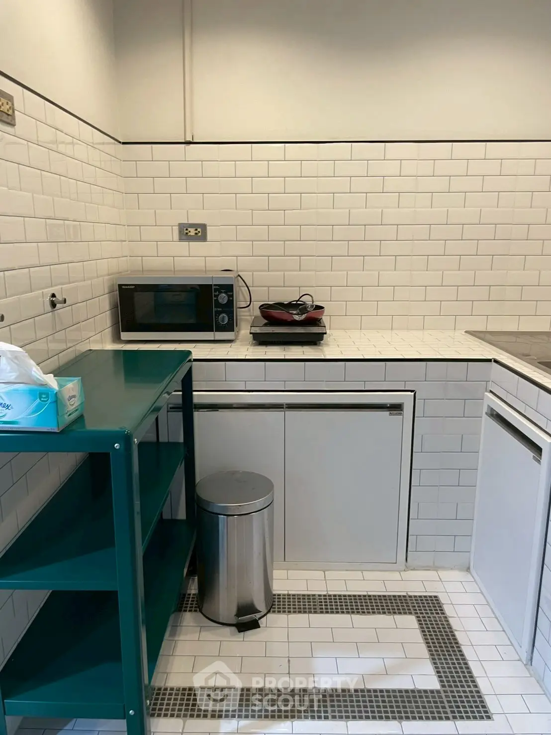 Compact kitchen with white subway tiles and modern appliances