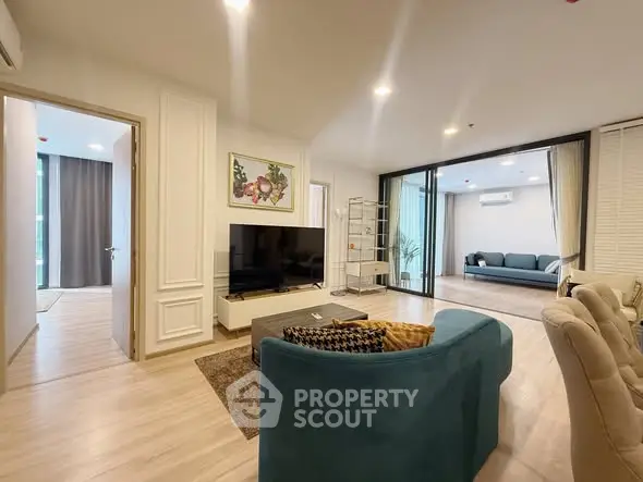 Spacious modern living room with elegant decor and large TV, perfect for relaxation.