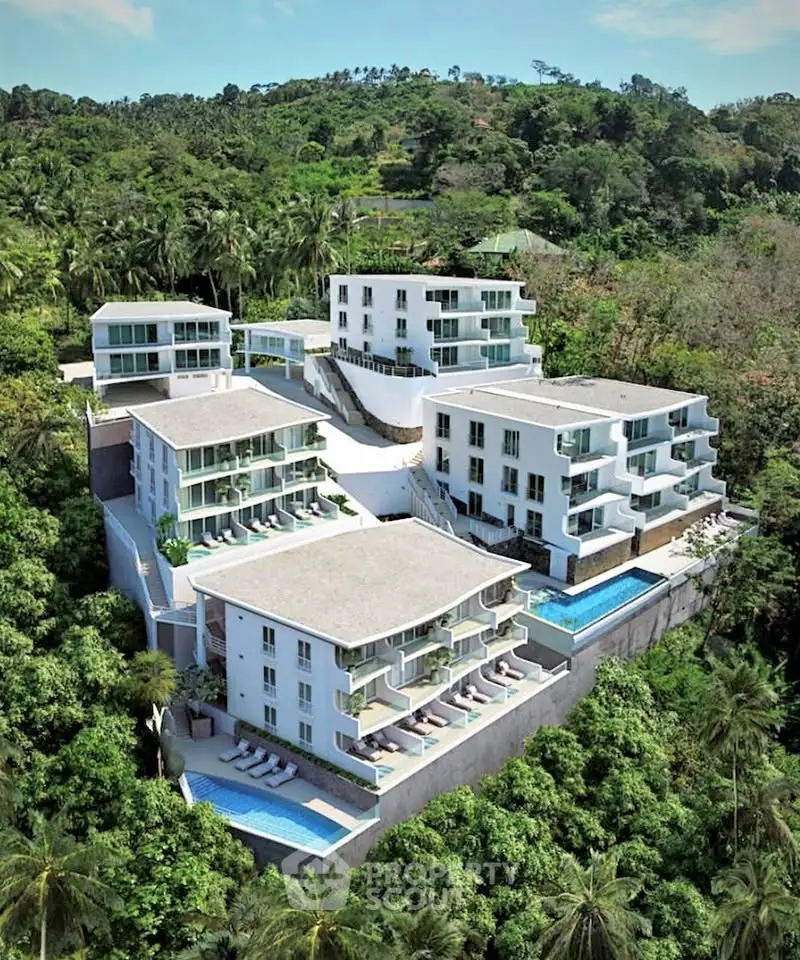 Luxurious hillside resort with stunning views and private pools nestled in lush greenery.