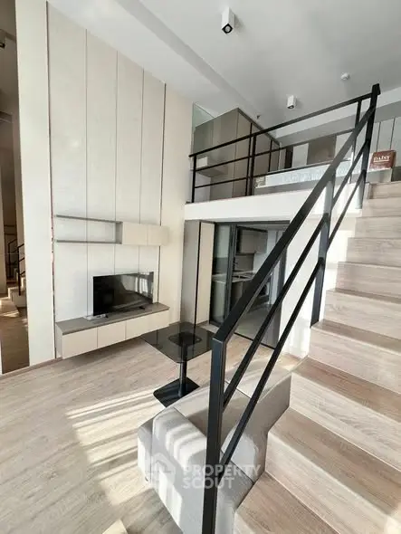 Modern loft-style living room with mezzanine and sleek staircase