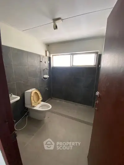 Spacious bathroom with modern dark tiles and natural light
