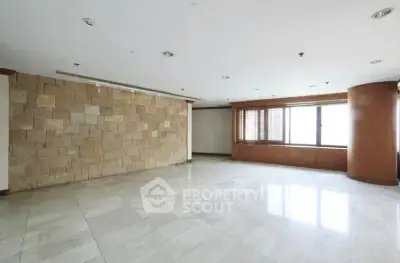 Spacious empty living room with stone accent wall and large windows