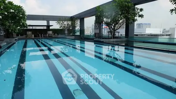 Luxurious rooftop pool with city views and lush greenery, perfect for relaxation and leisure.
