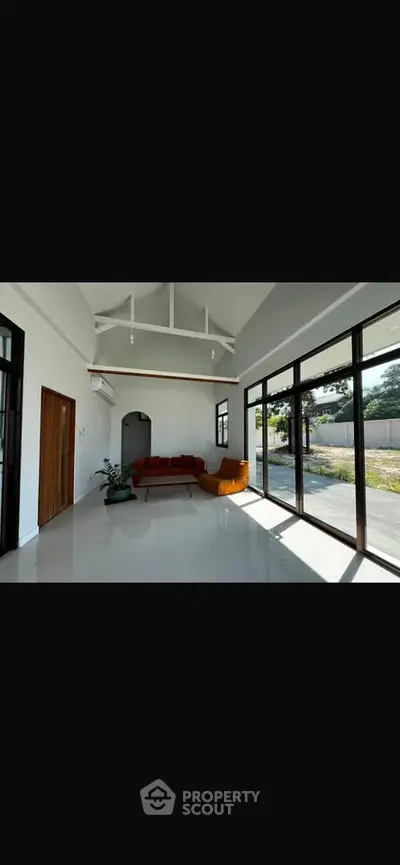Spacious modern living room with high ceilings and large windows offering abundant natural light.