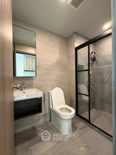 Modern bathroom with sleek shower and contemporary fixtures in stylish apartment.