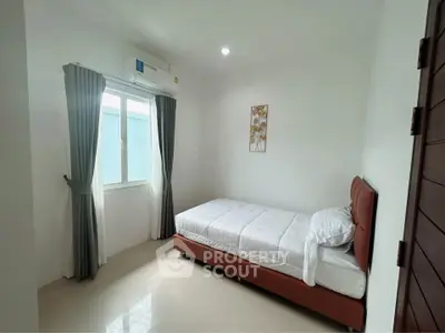 Cozy minimalist bedroom with single bed and natural light, perfect for a peaceful retreat.