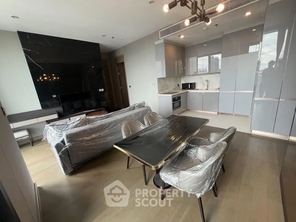 Modern open-layout living room with kitchen, featuring sleek furniture and contemporary design.