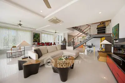 Spacious modern living room with elegant decor and open layout, featuring stylish furniture and natural light.