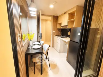 Modern kitchen with sleek design, compact dining area, and stylish lighting in a cozy apartment.