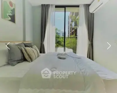 Bright bedroom with large window and modern decor in a stylish apartment.