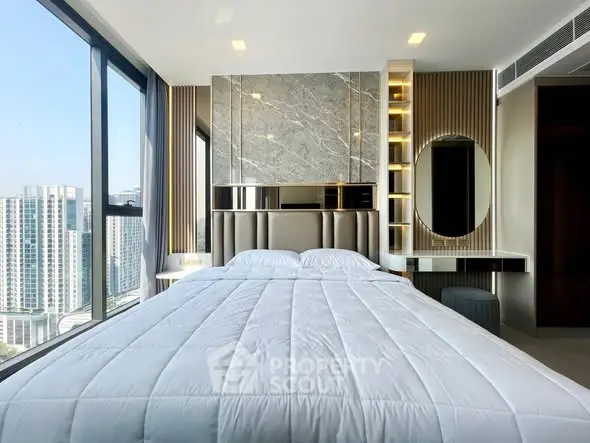 Luxurious bedroom with stunning city view and modern decor in high-rise apartment.