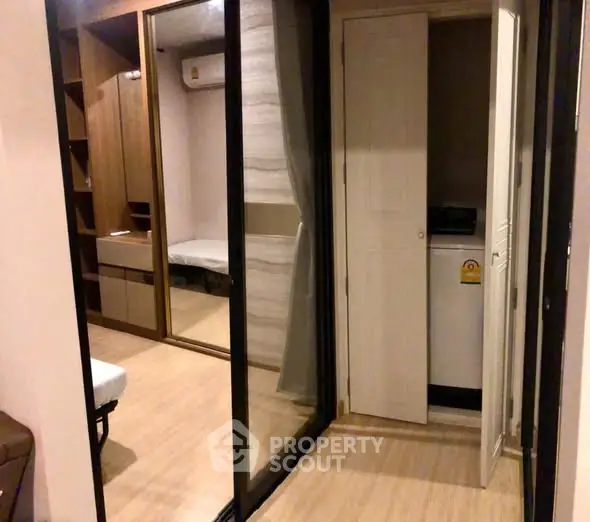 Modern apartment interior with mirrored closet and washing machine area