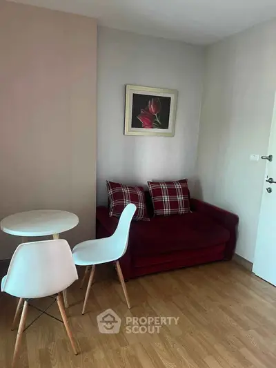 Cozy living room with red sofa and modern dining set on wooden floor