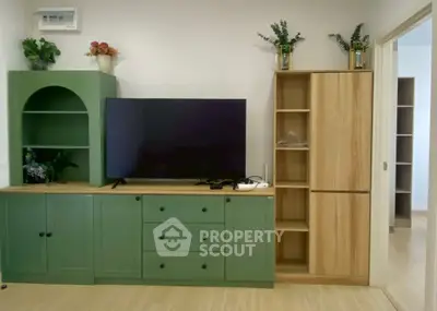 Stylish living room with modern green cabinetry and sleek TV setup