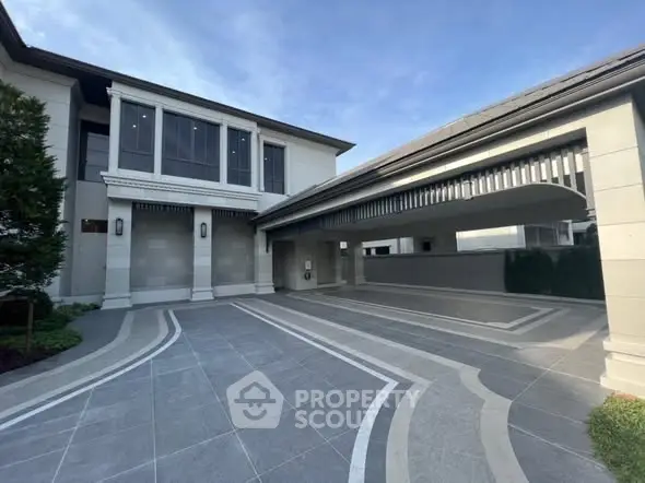 Elegant modern building exterior with spacious driveway and sleek architectural design.