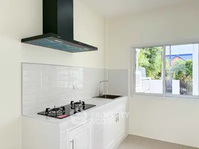 Modern kitchen with gas stove and sleek white cabinetry in a bright, airy space.